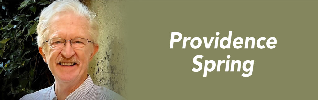 Photo of a white man in glasses with grey hair smiling for the camera, next to text that reads "Providence Spring."