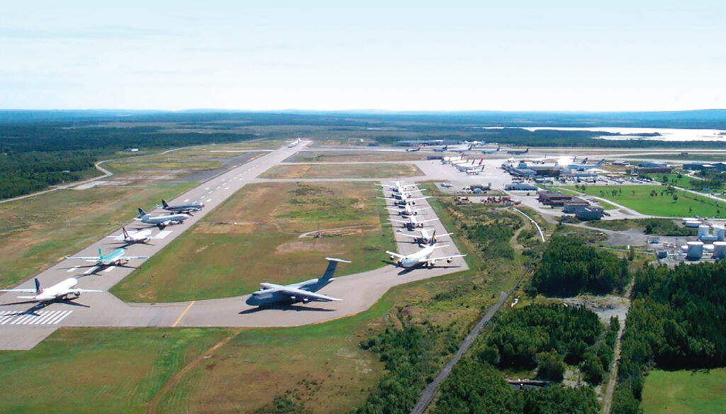 Aerial view of an airport with a long line of planes parked on the tarmac. 